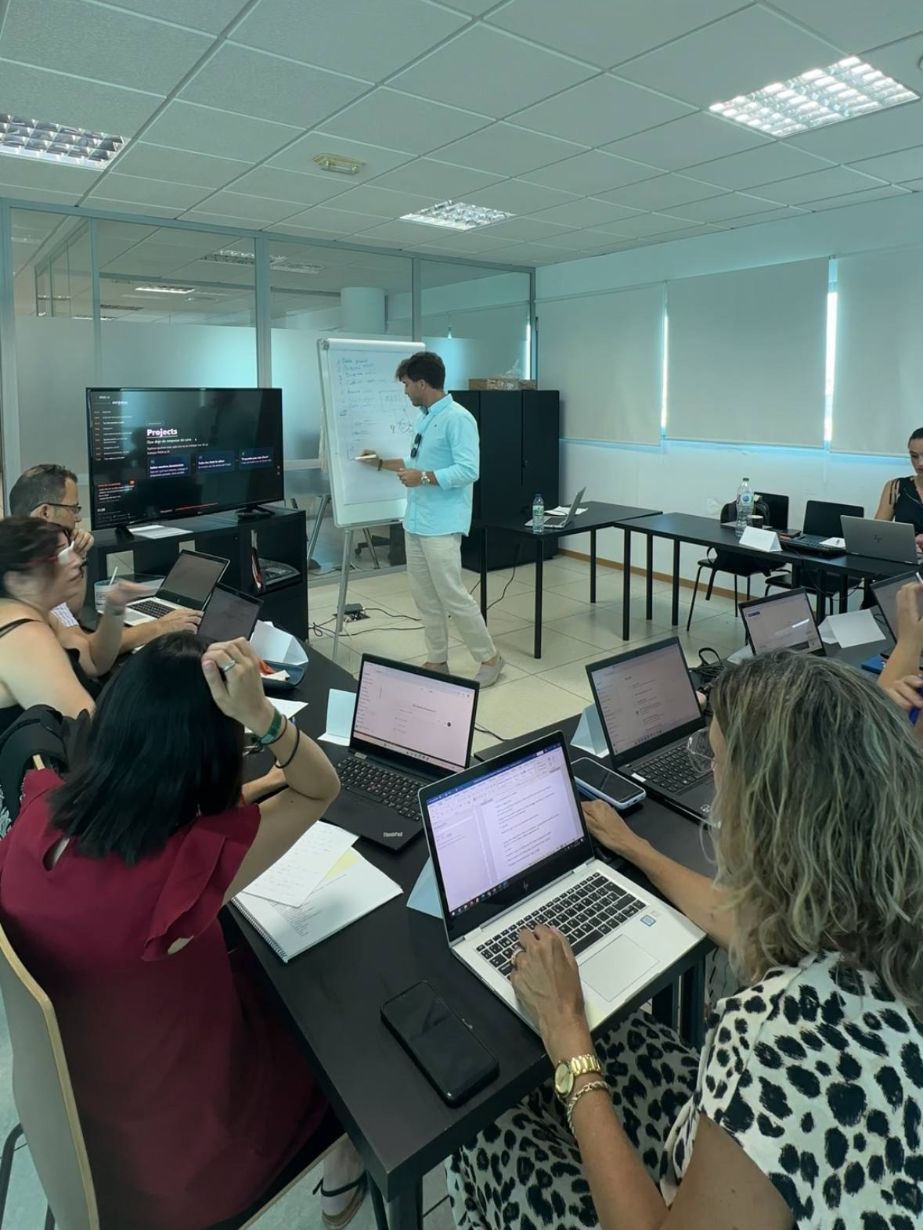 Jorge Marín explicando en la pizarra a un grupo de asistentes con sus portátiles