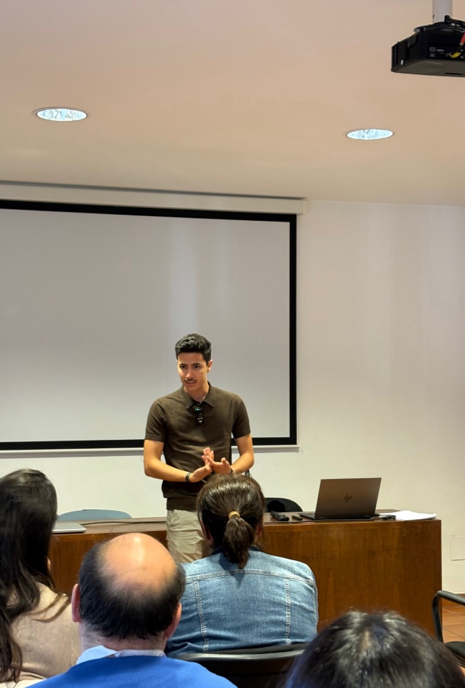 Isaac presentando con la pantalla al fondo y el público de espaldas